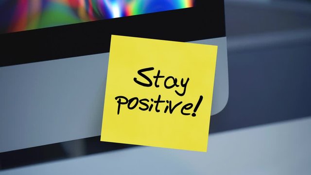 Stay positive. Sticky notes. The inscription on the sticker on the monitor. Message. Motivation. Reminder. Life motto in the workplace. Handwritten text written with a marker. Color sticker.	