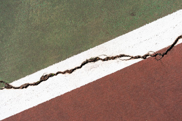 red and green paving separated by a white stripe and a crack for the concept of good vs bad