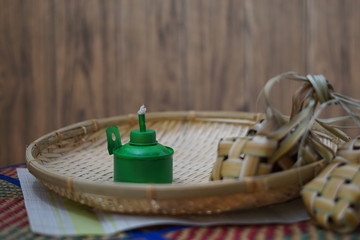 Traditional lamp and ketupat on Asian textured background