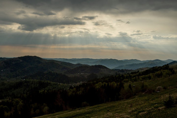 Fototapeta premium Beautiful sunset colors over the mountains of Carpathian, Ukraine, Europe. Sun setting after hot summer day. Photo in orange and blue natural tones.
