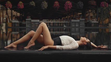 The girl lies on the background of the pool