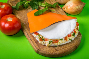 Tapioca with cheese, onion and tomato. Flatbread made from cassava also known as tapioca biju. Beiju of tapioca, cassava-based dish typical Brazilian food
