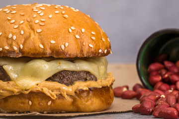 hamburger with cheese and peanut butter on brown paper on gray background. Close up