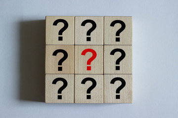 Close-up of wooden cubes in the form of a square with a question mark on them. Business decision...