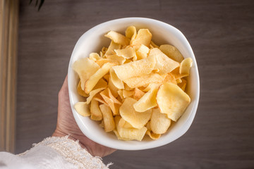 Hand with bowl with manioc chips