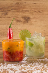 Caipirinha, Brazilian national cocktail made with cachaça, sugar cane liqueur and fruit on wooden background