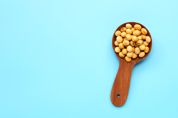 Soy Beans with wooden spoon on blue background.