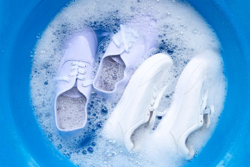 Fototapeta premium Soak shoes before washing. Cleaning Dirty sneakers.