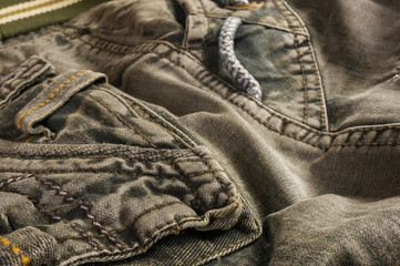 clothing items stonewashed cotton fabric texture with seams, clasps, buttons and rivets, macro