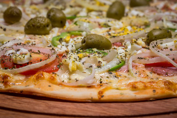 Portuguese Pizza, onion, peppers, pepperoni, egg, olive. Close up