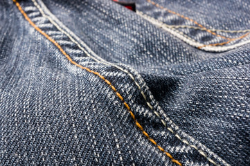 clothing items blue stonewashed faded jeans cotton fabric texture with seams, clasps, buttons and rivets, macro, close-up