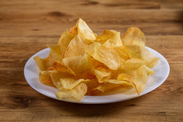 portion of potato chips on wooden background