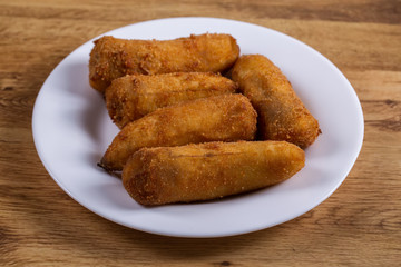 delicious fried breaded bananas on wooden background