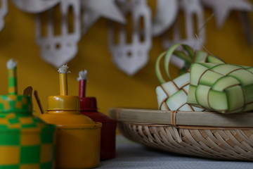 Traditional lamp and ketupat on Asian textured background