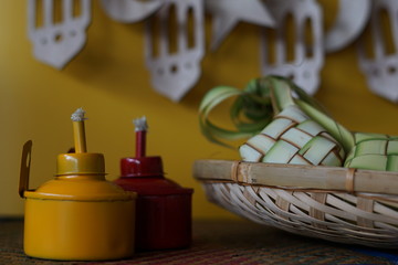 Traditional lamp and ketupat on Asian textured background