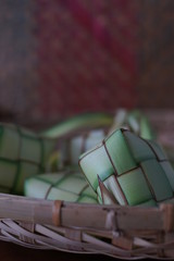 Traditional lamp and ketupat on Asian textured background