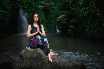 Fototapeta premium Yoga practice and meditation in nature. Woman practicing near river