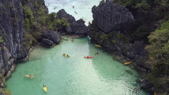 Aerial shot of kayakers enjoying vacation in turquoise twin lagoons in El Nido Palawan Philippines