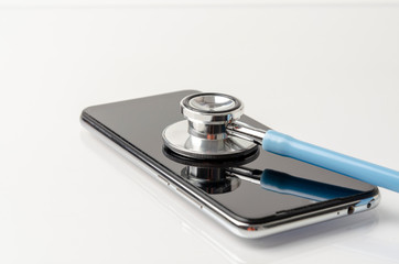 Telemedicine or telehealth, remote doctor video chat consultation concept with smartphone and stethoscope on white background.