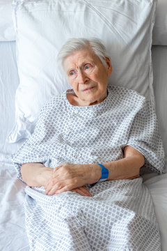 Personne &acirc;g&eacute;e sur lit d'h&ocirc;pital, triste