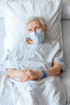 Personne &acirc;g&eacute;e sur lit d'h&ocirc;pital, avec masque chirurgical