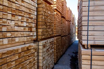 Pallets with wooden bars, a large warehouse of boards. Natural production from wood, for the construction of houses, furniture, and other products. Piles of wooden boards in the sawmill, planking