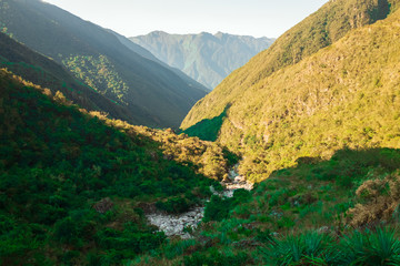 A River full of Rocks in the Middle of High Mountains full of Vegetation on the Choro Road in La...