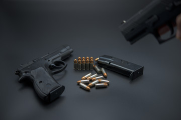 Gun with ammunition on iron dark background