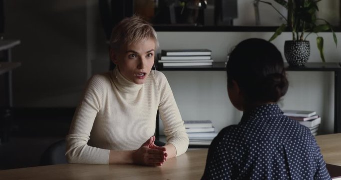 Two businesswomen negotiating and handshaking at office meeting. Confident young female candidate talking to hr recruiter shake hands getting hired making good first impression during job interview.