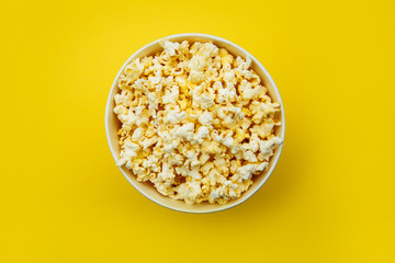 Popcorn viewed from above on yellow background. Flat lay of pop corn bowl. Top view.