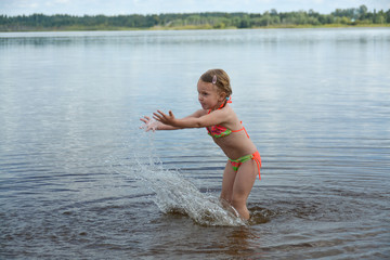 The girl enjoys swimming on the lake in summer. She really likes to splash in the water. 