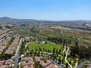 Aerial view of upper middle class neighborhood with residential houses in green valley, South California, USA.