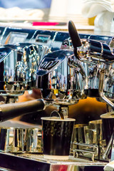 Espresso Machine pouring fresh coffee into cups at Local Coffee Shop..