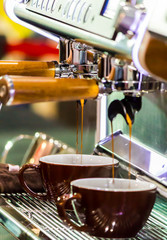 Fototapeta na wymiar Espresso Machine pouring fresh coffee into cups at Local Coffee Shop..