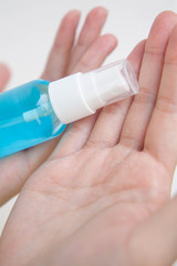 Closeup of cracked hands with alcohol spray bottle. Concept of using alcohol repeatedly during coronavirus pandemic crisis cause dry skin.