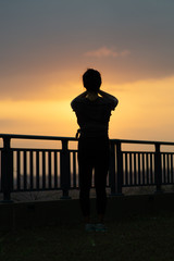 Fototapeta premium Young women doing Yoga meditation on a rooftop garden in an apartment during the lockdown during sunset
