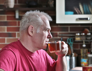 A man drinks tea in the kitchen