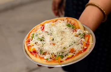 Home made Italian Pizza with Cheese and vegetables in Kitchen
