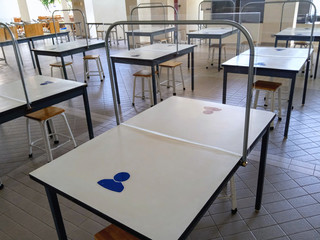 The white dining table has an acrylic plate in the middle to protect Covid-19