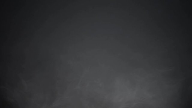 Atmospheric smoke 4K Fog effect. VFX Element. Haze background. Abstract smoke cloud. Smoke in slow motion on black background. White smoke slowly floating through space against black background.
