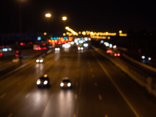 Blurred cars driving on a motorway at night. Seeing bokeh car headlights and taillights on the multiple lanes.