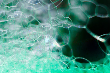 Abstract macro clean green foam shot background of soap bubbles