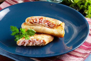 Russian pancakes with filling on a plate on a table in a restaurant