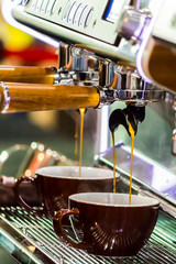 Espresso Machine pouring fresh coffee into cups at Local Coffee Shop..