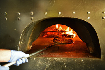 chef  with protective coronavirus face mask preparing pizza