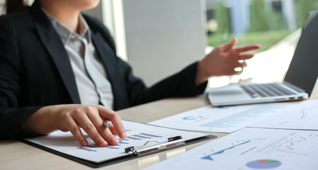 Financial or accounting professionals use a computer to analyze the company's revenue graph to prepare for presentation to the chief executive and partner, businessmen working in the room concept.
