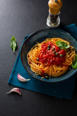 Vegan spaghetti with tomato sauce, pasta on dark