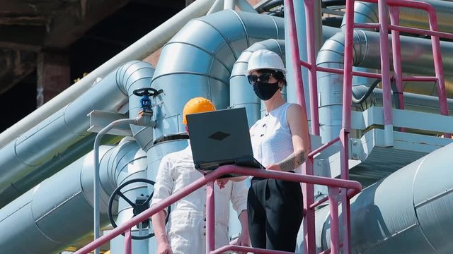 Female manager communicates with a worker in a factory. Gender specificity in the system of measures to reduce risk in the workplace.