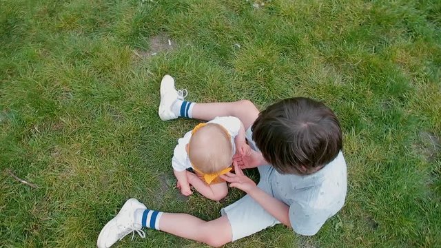 Children on green grass playing together in city park. New generation humanistic ideas.