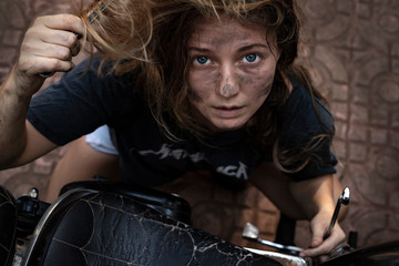 Fototapeta na wymiar girl fixing a motorcycle 